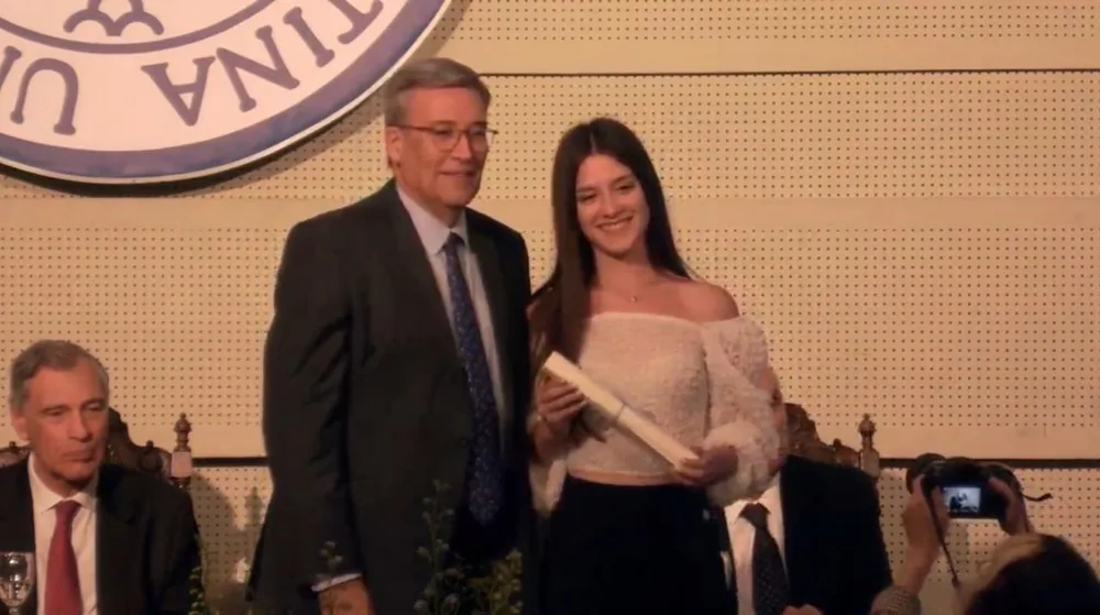 Pili receiving her diploma on stage.