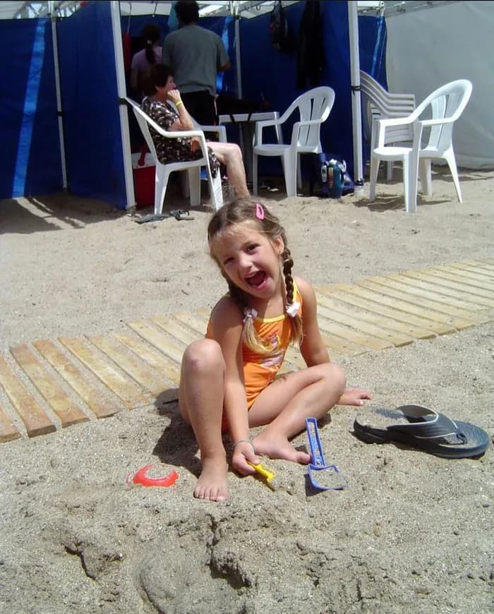 Pili as a child playing on the beach.